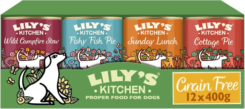 Pack de 12 latas de comida para perros Lily’s Kitchen, variedad grain‑free de 400 g, con diseños coloridos y un perro blanco ilustrado en cada sabor: Wild Campfire Stew, Fishy Fish Pie, Sunday Lunch y Cottage Pie