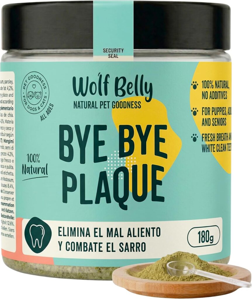 Envase de 180g del suplemento dental natural "Bye Bye Plaque" de la marca Wolf Belly para perros y gatos. El producto es un polvo verde contenido en un tarro transparente con etiqueta verde agua y amarilla, acompañado de una pequeña cuchara dosificadora sobre un cuenco de madera. La etiqueta destaca que es 100% natural, elimina el mal aliento y combate el sarro.