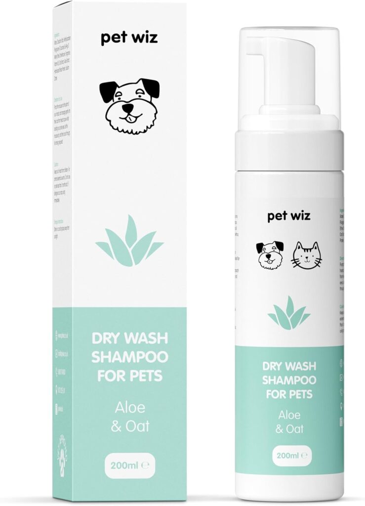 sp1 Imagen del champú en seco "Pet Wiz Dry Wash Shampoo" mostrando tanto la caja de cartón como el envase cilíndrico de 200ml. El diseño es minimalista en blanco y verde agua, con ilustraciones lineales de un perro, un gato y una hoja de aloe vera. La etiqueta destaca que es una fórmula de "Aloe & Oat" (Aloe y Avena) para mascotas.