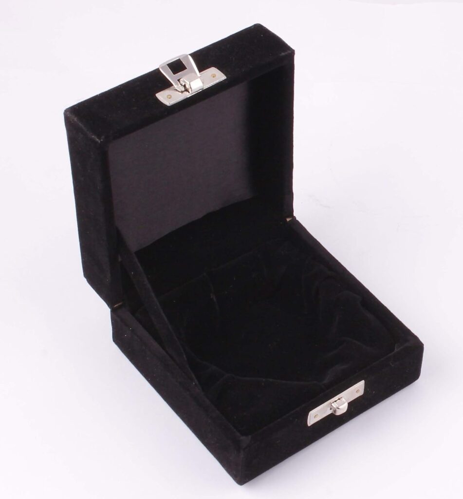 Caja de presentación cuadrada abierta, forrada en terciopelo negro tanto por fuera como por dentro. Incluye un cierre metálico plateado y un interior acolchado diseñado para proteger objetos delicados o urnas pequeñas.